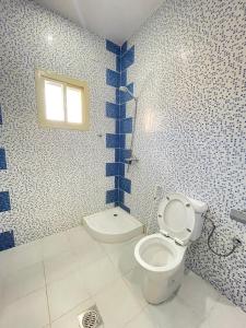 a bathroom with a toilet and a window at عليل الريف للشقق المخدومة in Al Baha