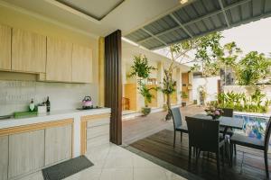 une cuisine ouverte et une salle à manger avec une table et des chaises dans l'établissement Happy Devi Guesthouse, à Canggu