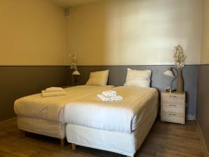 a bedroom with a large bed with two towels on it at Hotel Velsen in IJmuiden