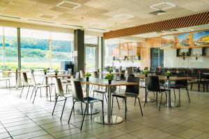 a restaurant with tables and chairs and windows at Hotel Ihtiman in Ikhtiman