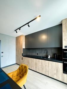 a kitchen with a yellow chair and a sink at Royal 2 apartments on Shevchenka 38 str in Lviv