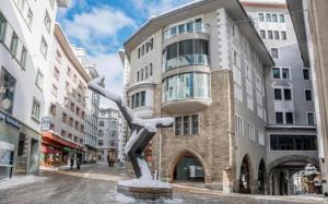 a statue of a person in front of a building at Luxorius living in the heart of St. Moritz Dorf in Celerina