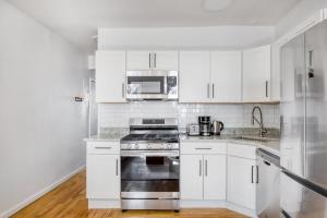 cocina blanca con fogones y microondas en Carroll Gardens 1BR w WD nr WF Waterfront NYC-759, en Brooklyn