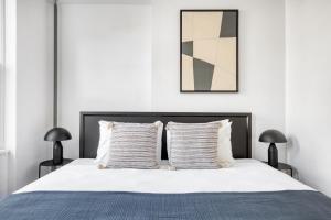 1 dormitorio con 1 cama con sábanas y almohadas blancas en Carroll Gardens 1BR w WD nr WF Waterfront NYC-759, en Brooklyn