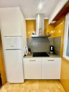 una cucina con mobili bianchi e un frigorifero bianco di Curros Enríquez MR a Ourense