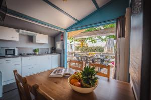 a kitchen with a table with a bowl of fruit on it at Camping le Roucan West in Vias