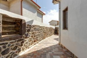 un muro di pietra accanto a un edificio bianco di Casa vacanze Ghilarza Sardegna a Ghilarza