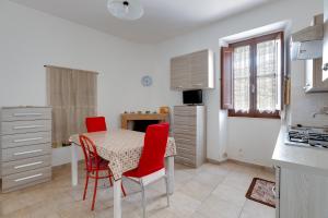 una cucina con tavolo e sedie rosse in una stanza di Casa vacanze Ghilarza Sardegna a Ghilarza