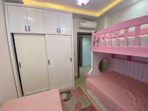 a bedroom with a pink bunk bed and white cabinets at Sharm Hills Aqua park Resort in Sharm El Sheikh