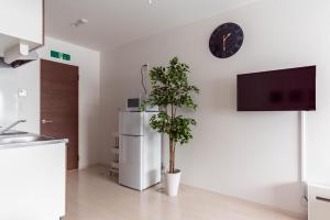 a kitchen with a plant and a clock on a wall at FDS Dernier in Osaka