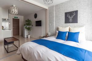a bedroom with a large bed with blue pillows at FDS Dernier in Osaka