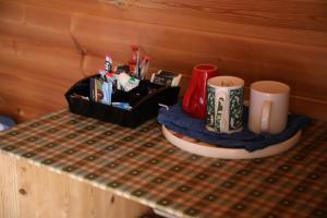 a table with two coffee mugs and a tray with at Clovullin Croftview Pod in Ardgour