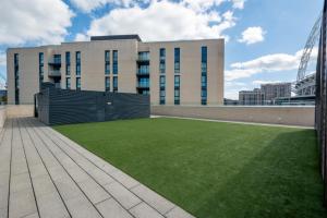 a large building with a lawn in front of it at Spacious Two Bedroom Apartment at Wembley Park in London