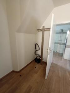 um quarto vazio com uma porta e um piso de madeira em kleine 1-Raum-Ferienwohnung mit hohem Komfort em Teuchern