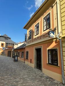a building on a cobblestone street next to a building at PENZION HRNČÍŘ in Kutná Hora