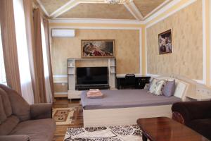 uma sala de estar com uma cama e uma televisão em BEST GUESTHOUSE em Tashkent