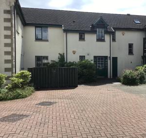 a house with a brick driveway in front of it at Wellingtonia Apartment in Inverness