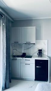 a kitchen with white cabinets and a counter top at Thalistris Room in Nydri +20 photos