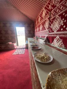 a buffet line with plates of food in a room at Wadi Rum fun camp in Wadi Rum