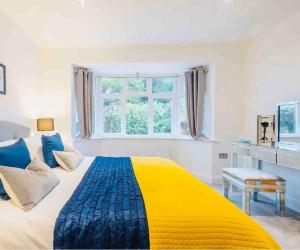 żółte i niebieskie łóżko w białym pokoju z oknem w obiekcie The Retreat w mieście Lymington