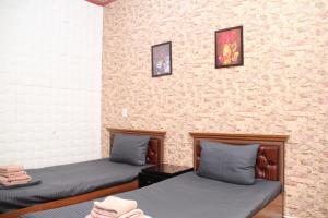 Pokój z 2 łóżkami i ceglaną ścianą w obiekcie BEST GUESTHOUSE w Taszkiencie