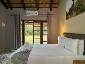 um quarto com uma grande cama branca e uma janela em 63 On Nyala, Lodge venue & conference em Stil Gelee