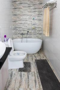 ein Badezimmer mit einer weißen Badewanne und einem WC in der Unterkunft Urban oasis in kingsland city in Lusaka