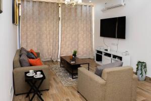 a living room with two chairs and a flat screen tv at Urban oasis in kingsland city in Lusaka