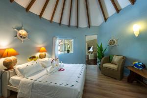 ニカ・アイランドにあるニカ アイランド リゾート ＆ スパ モルディブのベッドルーム1室(弓の付いたベッド1台付)