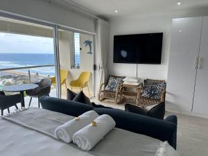 a bedroom with a blue couch and a view of the ocean at 514 Umdloti Resort Spectacular breakers view in Umdloti