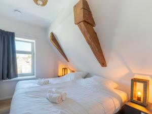 a bedroom with a white bed with towels on it at Modern renovated apartment in the heart of Sneek in Sneek