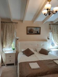 a bedroom with a large white bed and two windows at Apartments in a house in Jávea