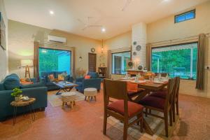 a living room with a table and a dining room at SaffronStays Dalewal Jungle Lodge, Hoshiarpur in Hoshiārpur
