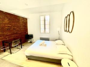 a bedroom with a bed and a brick wall at Le Caboteur - Studio proche Place de la Daurade in Toulouse