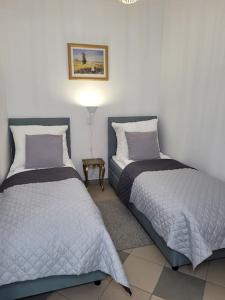 two beds sitting next to each other in a bedroom at Rynek 31 in Lubomierz