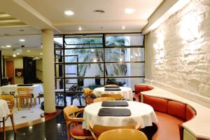 a restaurant with tables and chairs and a large window at Sarmiento Palace Hotel in Buenos Aires
