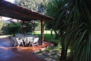 a patio with a table and chairs under a pavilion at Villa Marisa in Fregene