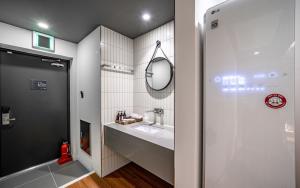 uma casa de banho com um lavatório e um espelho em Brown Dot Hotel Sajik Baseball Stadium em Busan