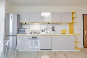 uma cozinha com armários brancos e um frigorífico em MILAN MCHOME em Trezzano sul Naviglio