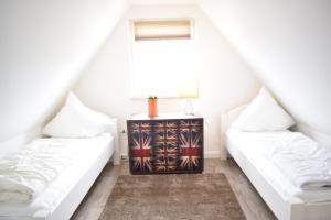 2 białe łóżka w pokoju z oknem w obiekcie Ocean Way House w mieście Haffkrug