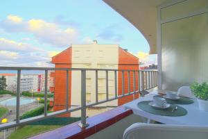 balcón con mesa y vistas a un edificio en Acacios en La Concha en Suances