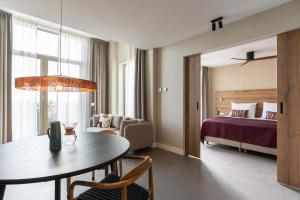 een hotelkamer met een slaapkamer en een tafel en een bed bij BizStay Walden in Den Haag