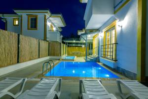 uma piscina no quintal de uma casa à noite em Yellow Villa em Muğla