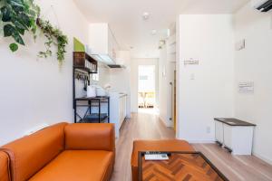 Una sala de estar con un sofá naranja y una mesa. en アンドステイ上高田2丁目, en Tokio 42 fotos más