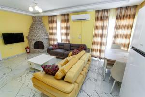 uma sala de estar com um sofá e uma lareira em Yellow Villa em Muğla