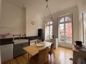 uma cozinha com uma mesa e uma sala de jantar em L'Hypercentre - Au coeur de la vie Toulousaine em Toulouse