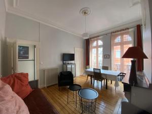 een woonkamer met een tafel en stoelen. bij L'Hypercentre - Au coeur de la vie Toulousaine in Toulouse