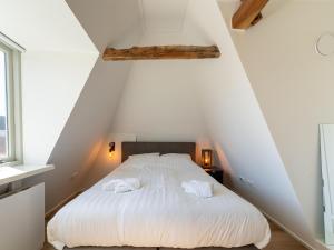 een slaapkamer met een wit bed en 2 handdoeken bij Modern renovated apartment in the heart of Sneek in Sneek