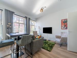een woonkamer met een tafel en stoelen bij Modern renovated apartment in the heart of Sneek in Sneek