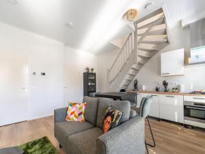 een woonkamer met een bank en een trap bij Modern renovated apartment in the heart of Sneek in Sneek